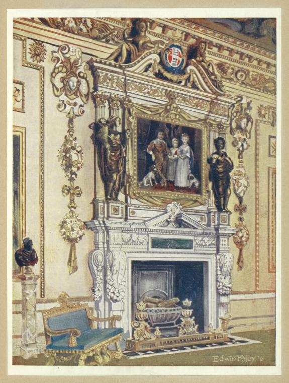 an interior scene featuring an ornate fireplace and surrounding room decor. the fireplace has a large, decorative frame above it containing a painting of a family with dogs. sculptures flank the fireplace. a blue and gold chair sits to the left, with a bust on a column behind it. the room is highly decorated with classical motifs.