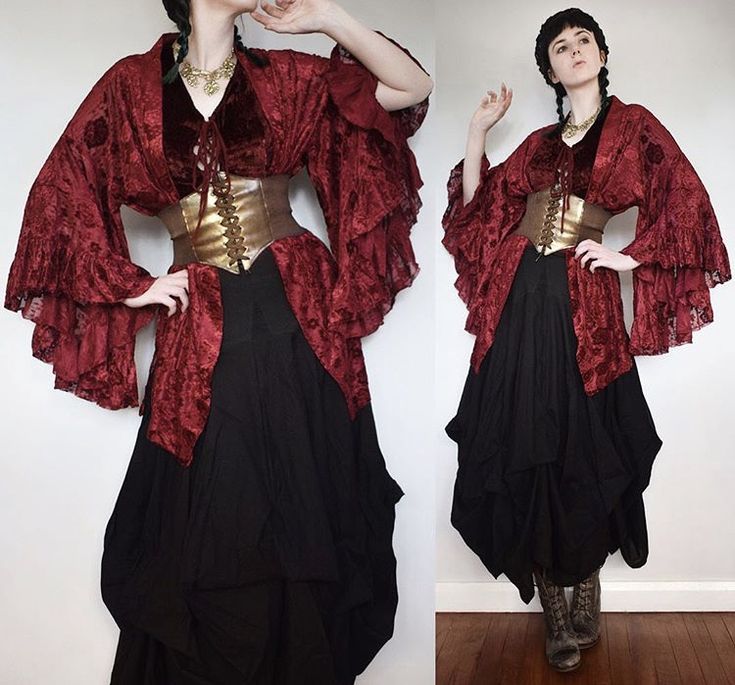 a woman is wearing a red and black dress. the dress is a long, flowing skirt with a red ruffled top. the top is a vintagestyle corset that is laced up the front. the woman is wearing a black skirt and a red ruffled top. she has her hair up in a braid. the woman is in a studio setting and is posing for the camera.