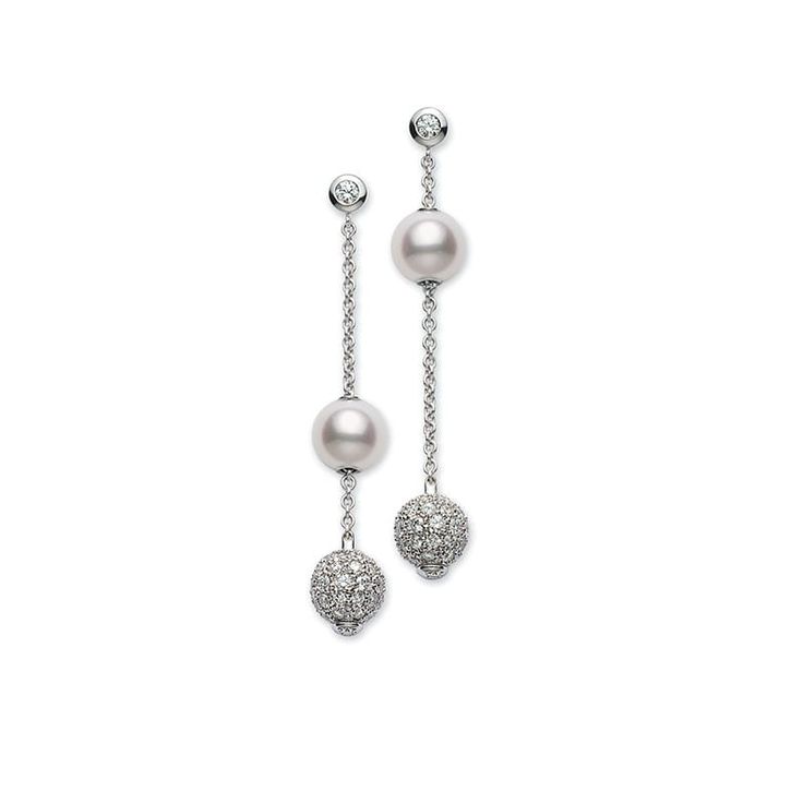 a pair of silver earrings with white pearls and diamonds. the earrings are made of a delicate chain with two spheres on each earring. the top sphere is a white pearl, and the bottom sphere is a diamondstudded ball. the earrings are elegant and delicate, and would make a beautiful gift for any occasion.