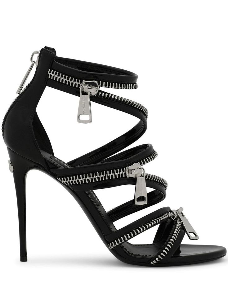 a pair of black, highheeled sandals are shown in the image. the sandals are made of patent leather and have multiple straps that are fastened with zippers. the heels are stiletto heels, and the shoes have a pointed toe. the shoes appear to be designed for women and are likely to be considered a fashion item.  they are shown against a white background.