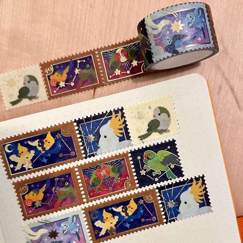 a closeup shot of washi tape featuring a series of illustrated postage stamps with various birds against a night sky background. the tape is unrolled and arranged on a notebook page, where additional strips of the tape have been affixed, creating a cohesive collage of charming bird designs.  the overall aesthetic is cute, vintage, and celestial.
