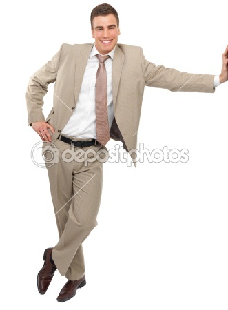 a young man in a beige suit and tie smiles confidently as he leans against a white background with his arm extended.