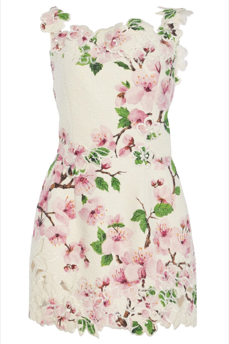the image shows a sleeveless, strapless dress with a floral cherry blossom pattern. the dress is white with pink cherry blossoms and green leaves. it features lace details around the edges and on the straps. the dress is short and appears to be made of a textured fabric.
