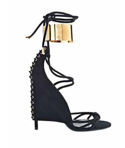 a pair of black suede high heeled sandals with a gold buckle strap around the ankle. the sandals have a delicate strap design and a slightly pointed toe. they are perfect for a summer party or evening out.