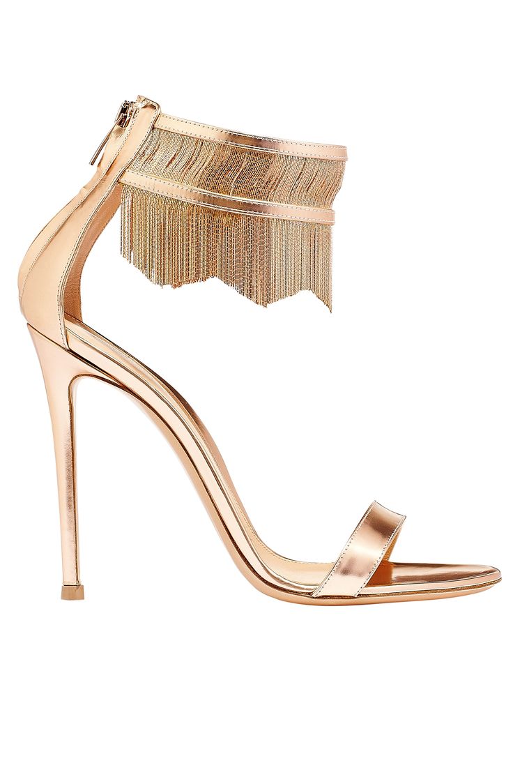 the image shows a pair of elegant rose gold highheeled sandals.  the sandals have a thin stiletto heel, an ankle strap adorned with a double layer of gold chain fringe, and a simple single strap across the toes. the shoes are made of what appears to be metallic rose gold leather. the overall style is sophisticated and glamorous, suitable for formal occasions or evening wear.