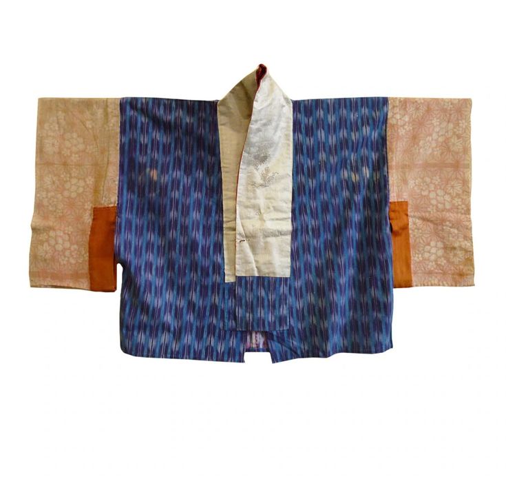 a kimonostyle jacket with a blue and white patterned body, beige sleeves with a floral design, and a light beige collar. it is laid flat against a white background.