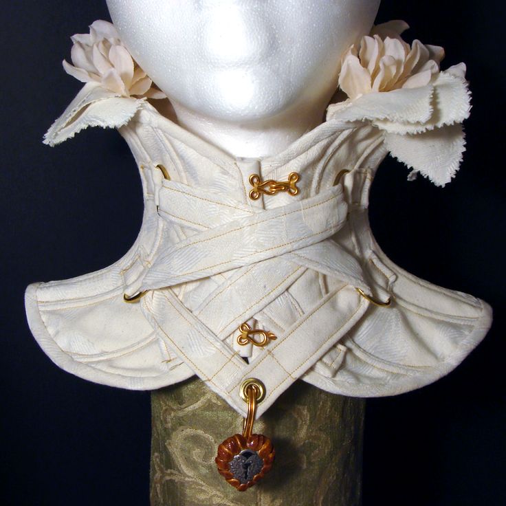 loseup view of an exquisitely crafted offwhite corset choker. the choker is made of a delicate, possibly brocade, fabric with a pattern barely visible. it features a crisscross lacing pattern secured with small goldcolored metal clasps.  the edges of the choker are softly curved and structured.  two artificial offwhite roses adorn the upper part of the choker, adding a touch of romance. the choker is displayed on a mannequin head and rests on a green, textured stand. a small, heartshaped locket with a keyhole is attached to the bottom of the corset. the overall aesthetic is a blend of victorian, steampunk, and romantic styles. the image highlights the fine details and craftsmanship of the piece.