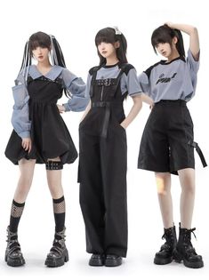 three women are posing in stylish punk/gothic outfits against a white background. each woman showcases a unique outfit that incorporates elements of grunge, streetwear, and dark academia styles. the first woman on the left wears a black overall dress with a light blue sheer top. the second woman sports a black jumpsuit with a belted waist and a graphic tee. the third woman rocks a pair of black cargo shorts with a graphic tee and a sheer longsleeved top. all three women complete their edgy looks with accessories like fishnet stockings and chunky black boots.