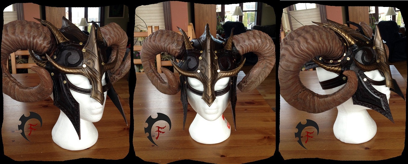 the image shows a fantasystyle helmet with large, curved ram horns, presented in a triptych. the helmet is displayed on a white mannequin head, which rests on a wooden table. the helmet itself is intricately designed with a dark brown leather base and bronzecolored metal accents. it includes pointed projections and ornamental patterns, creating a gothic or fantasyinspired aesthetic. the ram horns are a prominent feature, curving dramatically on either side of the helmet. the background suggests an indoor setting with natural light. the triptych presents the helmet from different angles: a side view, a frontal view, and another side view, to showcase its design and construction in detail. a logo appears in each section of the triptych.
