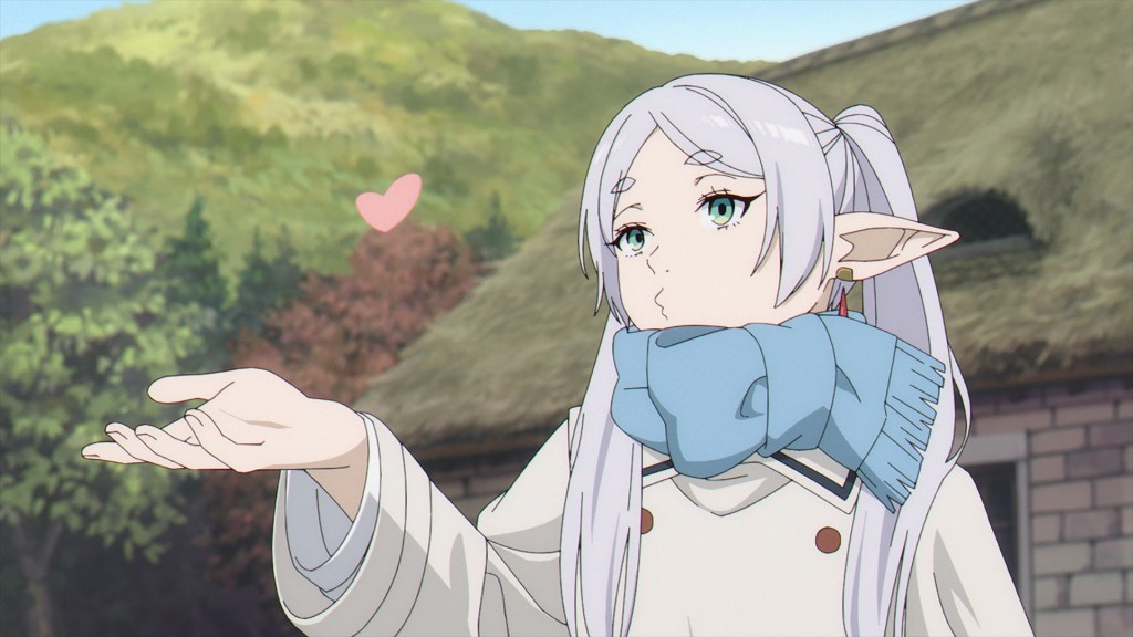 a girl with long white hair and pointy ears like an elf is holding out her hand with a pink heart floating above it. she is wearing a white jacket, blue scarf, and has green eyes. she is looking up towards the heart and has her lips puckered as if giving a kiss. the background is a green hill with trees and a brown roof visible behind her.