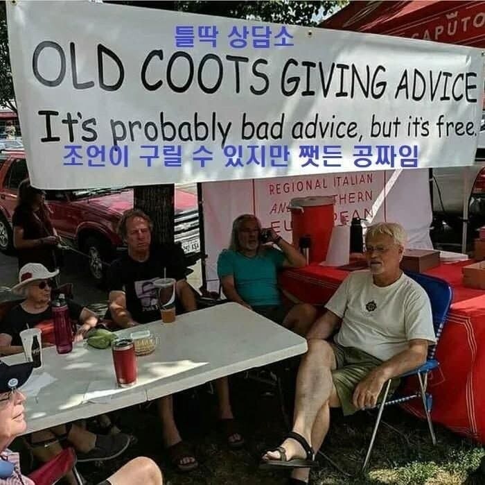 the image shows a group of older people sitting at a table under a banner that reads "old coots giving advice. it's probably bad advice, but it's free." there are several people sitting around the table, and some are drinking from cups. there is a red car visible in the background.
