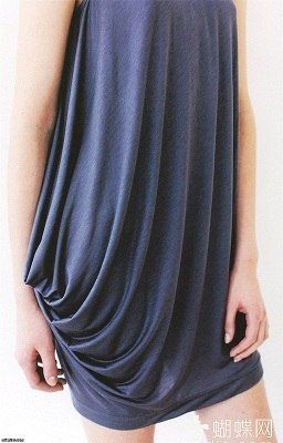 a woman is wearing a blue dress with draping on one side. the dress is short and has a relaxed fit.