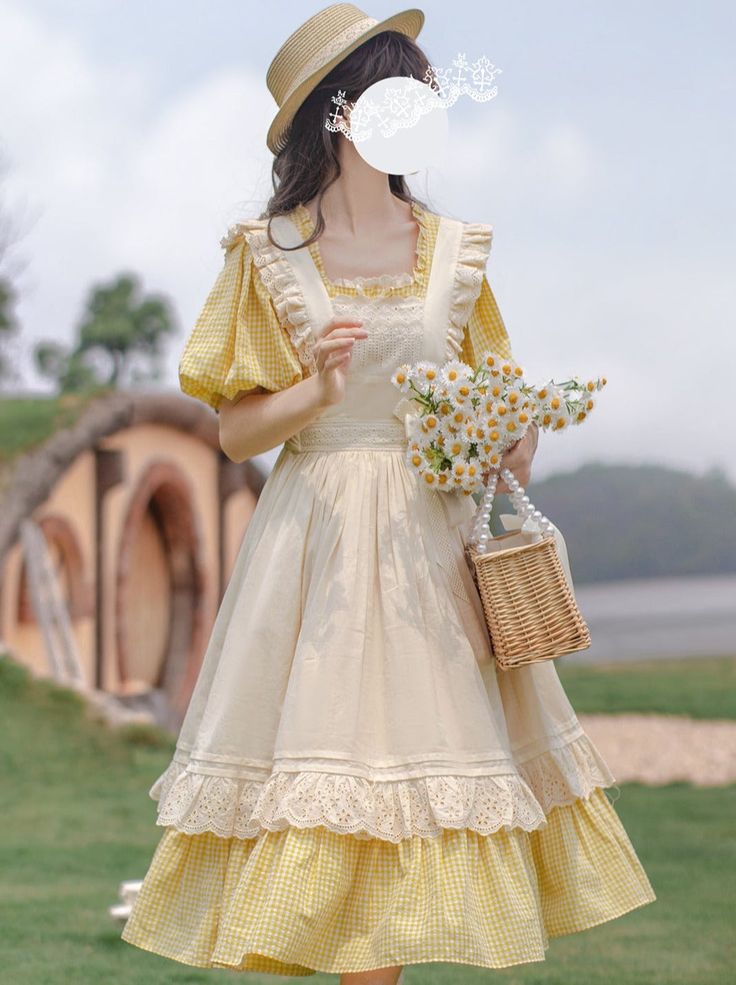 a woman in a yellow and white lolita dress stands in a field. she is holding a basket and a bouquet of daisies. the dress is a light yellow and white with lace detailing. the woman is wearing a straw hat. the background is a field with a lake in the distance.