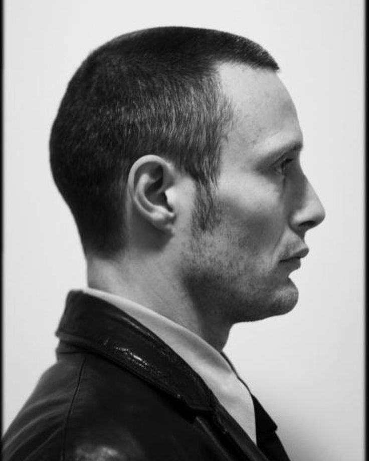 a black and white portrait of a caucasian man in profile. he has short hair and is wearing a leather jacket.