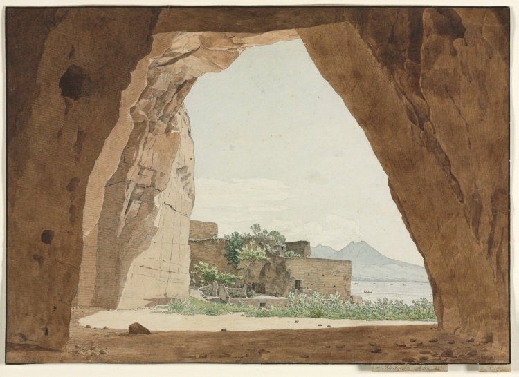 the watercolor painting depicts a scene viewed through a rocky cave opening. in the foreground, the interior of the cave is visible, with rough, textured rock formations framing the view. through the opening, a landscape unfolds with buildings, vegetation, and a body of water. in the distance, mountains are visible under a light sky. the overall impression is one of natural beauty and architectural harmony within a rugged setting.