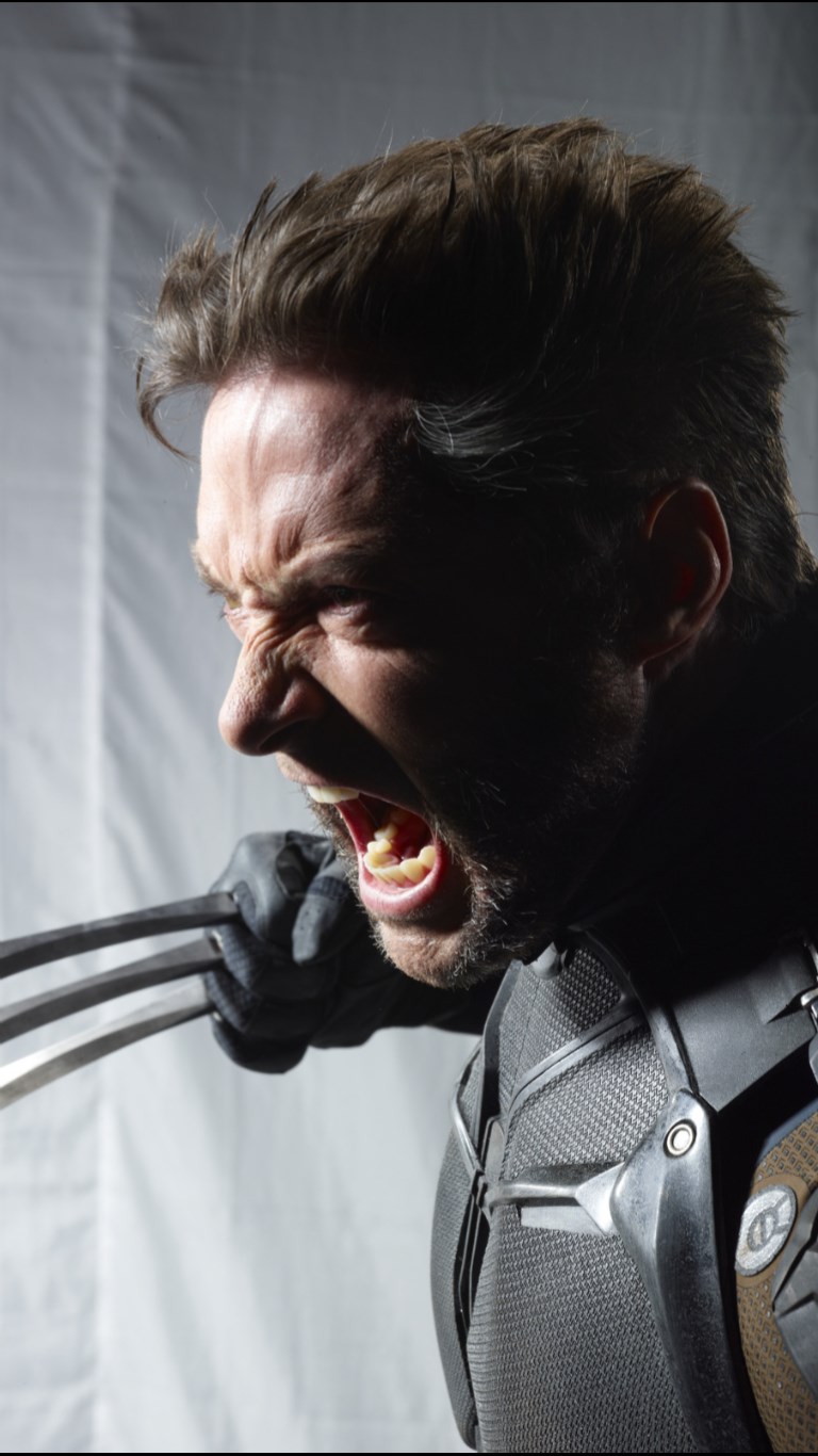 a portrait of hugh jackman as wolverine from marvel comics. he is wearing the character's costume and has his claws extended. he is snarling with rage. the background is out of focus.
