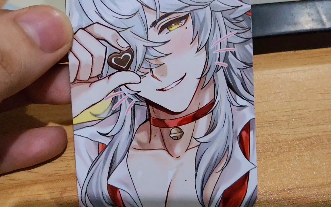 an anime character with white hair is holding a heartshaped chocolate in front of their face. they are smiling and wearing a red collar and red clothes. the character appears to be a man. this appears to be fan art of a character.