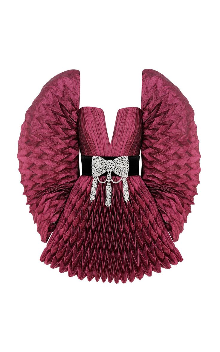 a burgundy, pleated dress with puffed sleeves and a vneck. the dress has a black belt with a jeweled bow.