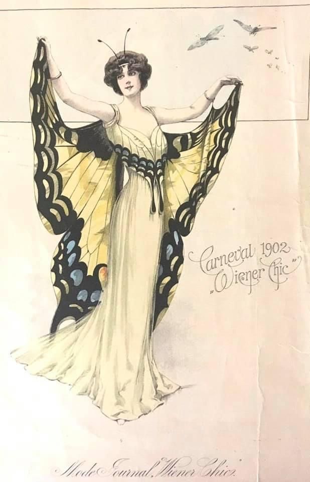 a vintage fashion illustration in the art nouveau style depicts a woman in a butterfly costume. she wears a long, lightcolored dress and large butterfly wings that are yellow, black, and blue. the text "carnaval 1902" and "wiener chic" are written next to the image, along with "mode journal. wiener chic." at the bottom.