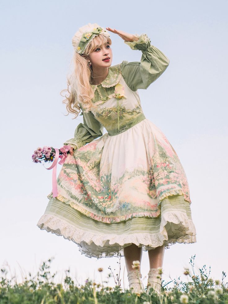 a young woman in a flowy, pastel green and white lolitastyle dress stands in a grassy field. she is holding a bouquet of flowers in one hand and shielding her eyes from the sun with the other. her dress features a floral print and delicate lace trim. the image has a soft, dreamy quality, with natural light and a low camera angle.