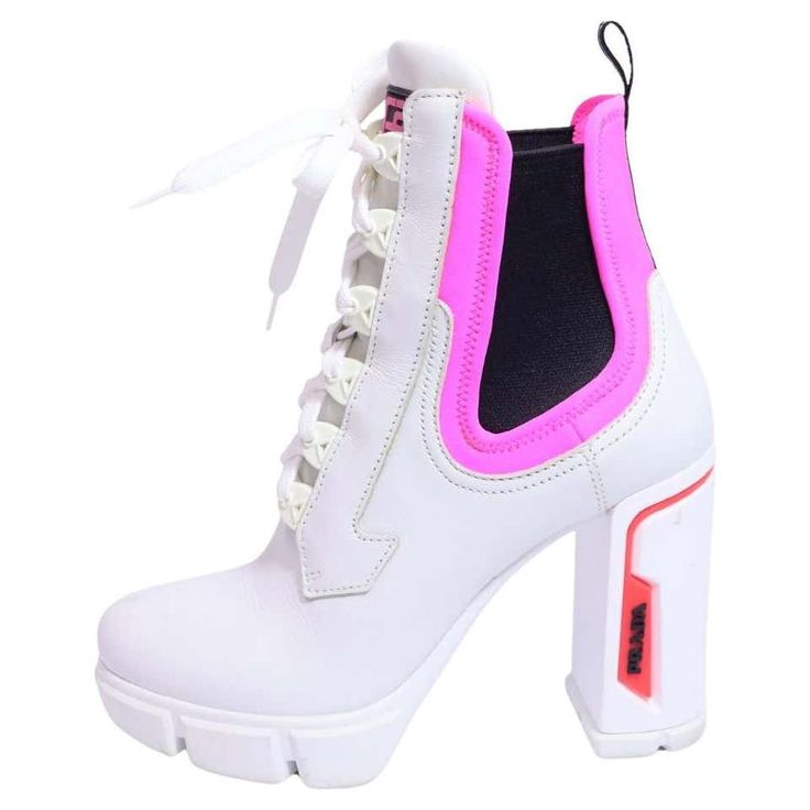 a pair of white leather highheeled boots with pink accents and a black elastic panel on the back of the ankle. the boots are laceup and have a platform sole. the prada logo is visible on the side of the heel.