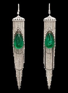 a pair of elegant, emerald drop earrings that feature diamondstudded details and a dangling, chandelierlike design.
