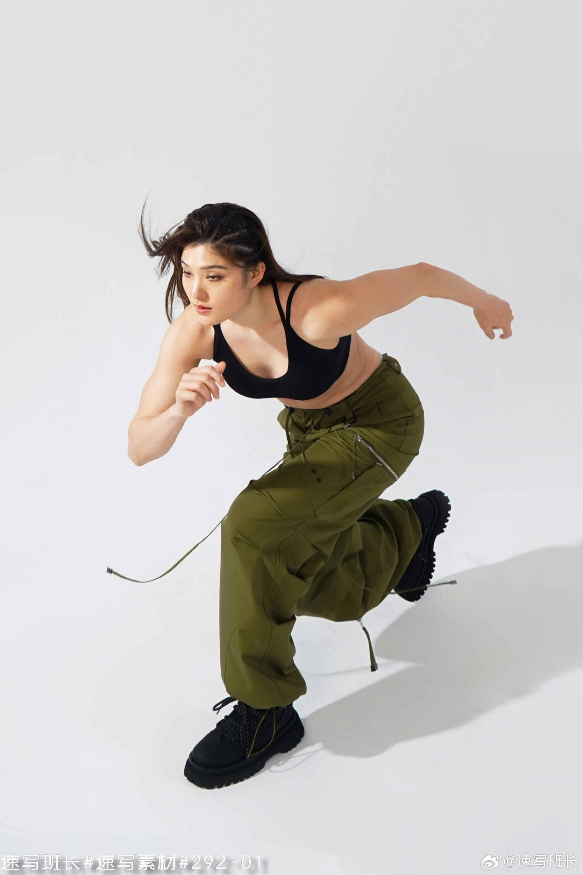 a woman in athletic wear is captured midstride, showcasing a powerful and dynamic running motion. the studio lighting highlights her athletic build and the intensity of her movement.