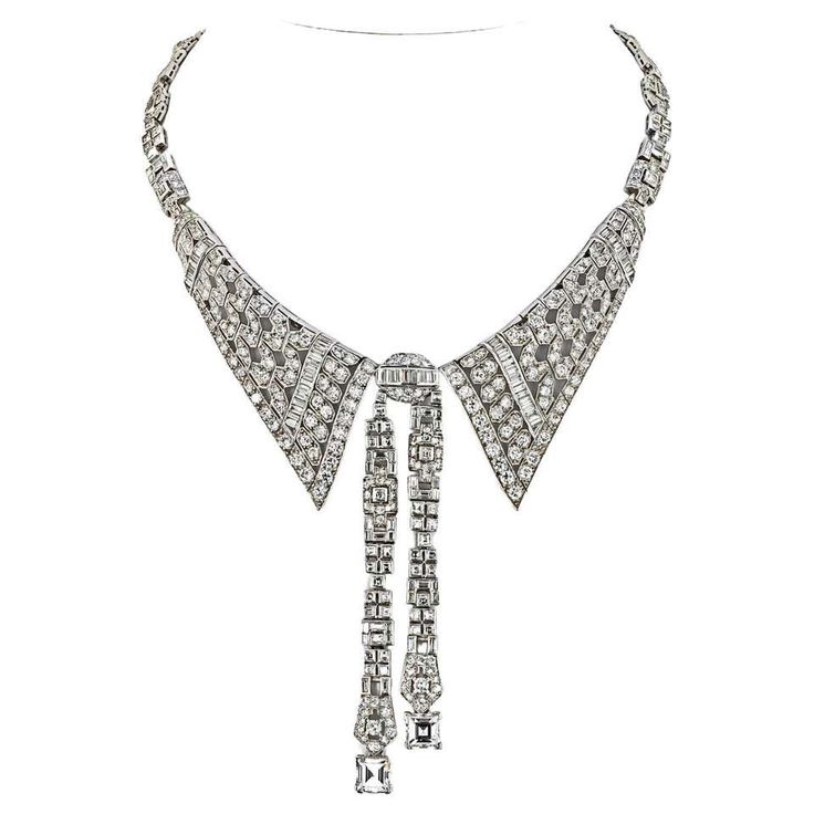 a stunning vintage diamond necklace with a collar style design. the necklace features a beautiful geometric pattern with a tie pendant that hangs from the collar. the necklace is crafted from platinum and is set with brilliantcut diamonds. it's a glamorous and timeless piece of jewelry that's sure to make a statement.