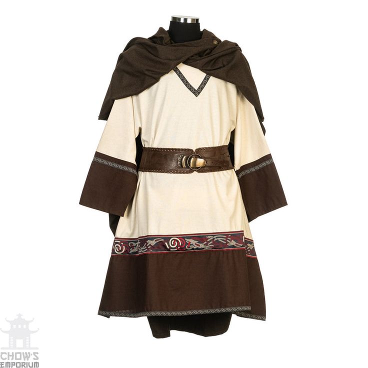 a creamcolored tunic with long sleeves and a brown trim. it is belted with a brown leather belt. the tunic has a brown hood that is draped over the shoulders. the tunic is also decorated with a brown, red, and grey trim along the bottom hem. the outfit is worn on a dress form.