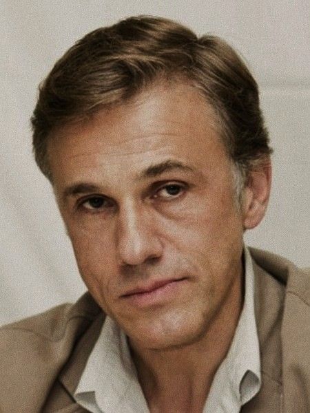 a portrait of actor christoph waltz, a lightskinned man with light brown hair wearing a white shirt and beige jacket.