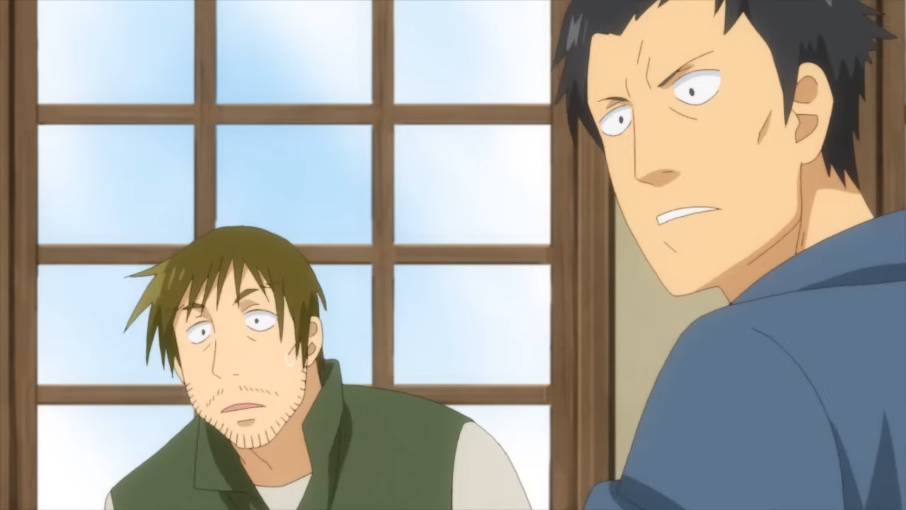 the image shows two men with shocked expressions on their faces. the man on the left has brown hair and a beard, and is wearing a green vest. the man on the right has short black hair and is wearing a blue shirt. they appear to be looking at something offscreen. the scene is set indoors, with a window in the background. the lighting is natural and bright. the overall impression is one of surprise and concern.
