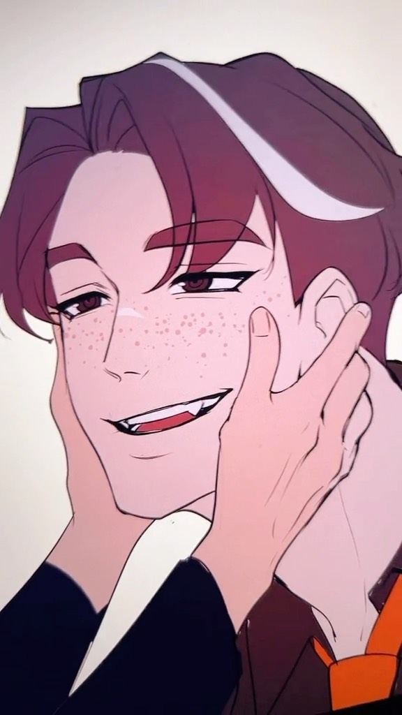 a closeup illustration of a young animestyle man with freckles and fangs, his face gently cupped by another person's hands. he has brown hair with a distinctive white streak, and is wearing a dark jacket with an orange tie visible at his collar. the style is romantic and affectionate.