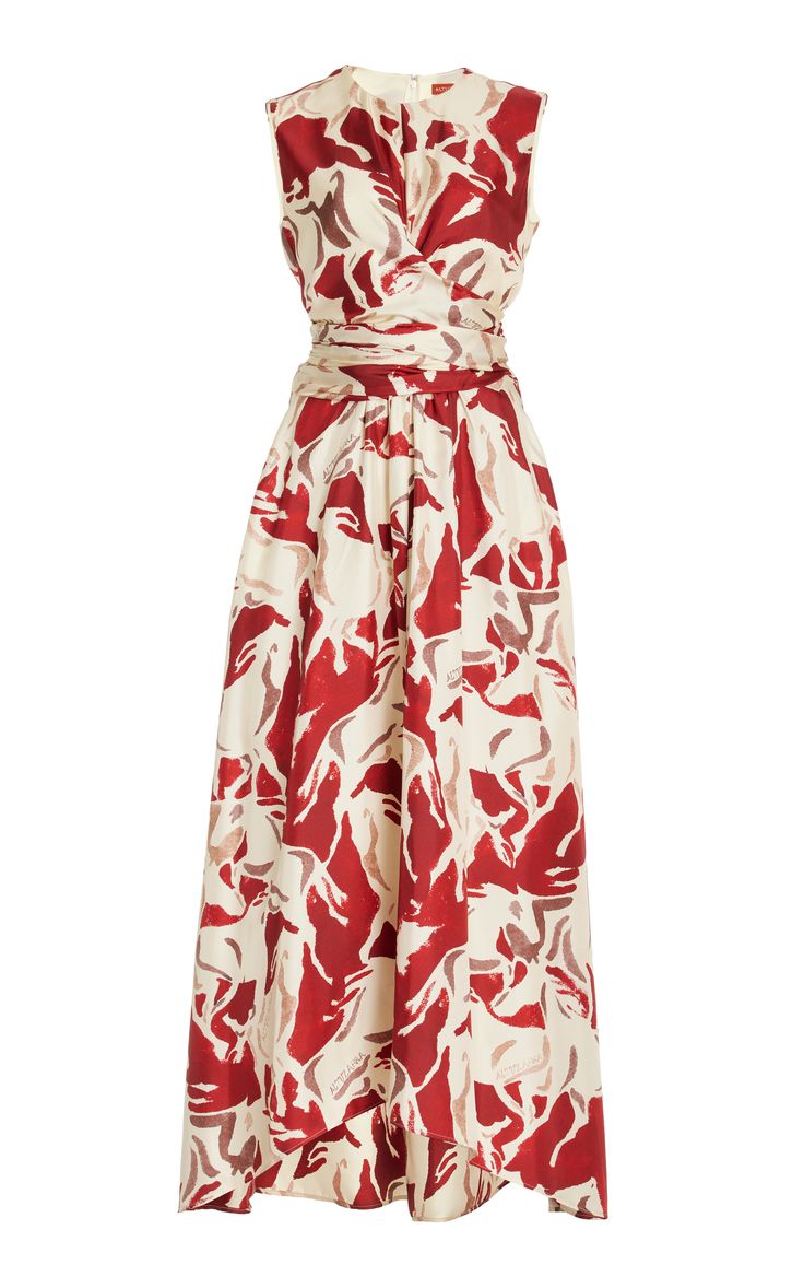 a white sleeveless maxi dress with a red floral print. the dress has a vneckline and a fitted bodice. the skirt is flowy and slightly gathered. the dress is perfect for a summer party or a casual occasion. it is both elegant and sophisticated.  the dress is a great choice for a woman who wants to look stylish and feel comfortable.  the dress is also versatile and can be dressed up or down depending on the occasion.