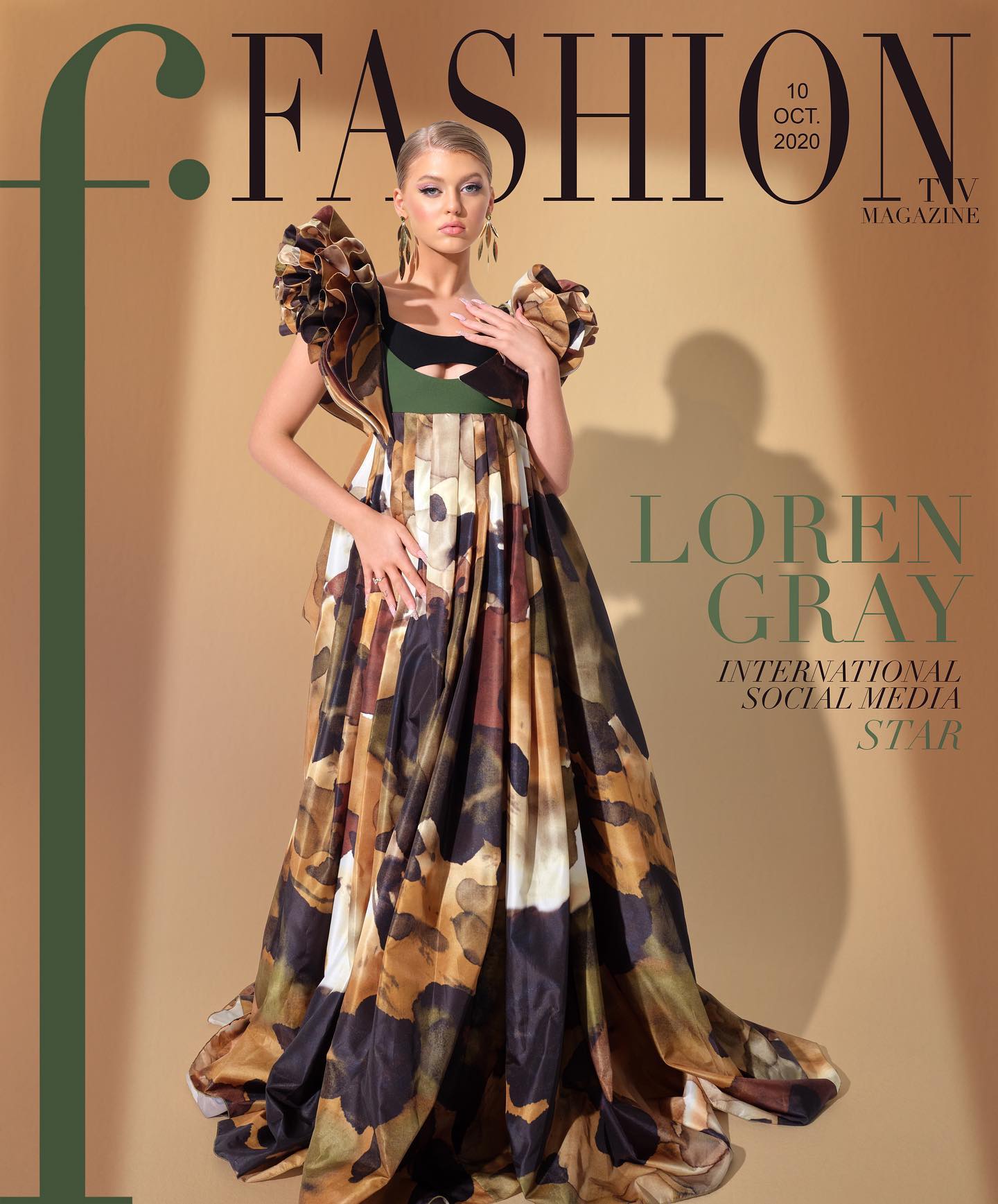 the image is a magazine cover featuring loren gray, an international social media star, wearing a patterned formal dress with large ruffled sleeves. the magazine title is "fashion tv magazine" and the cover is dated october 10, 2020. gray is posing elegantly with her hand near her chest. she is wearing dangling earrings. the background is a gradient of tan and olive green.