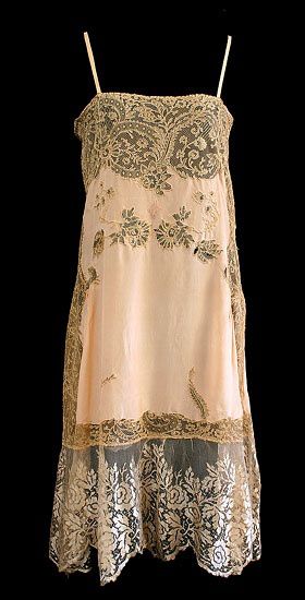 a vintage lace and silk dress from the 1920s. the dress is made of a pale pink silk and features delicate lace embroidery throughout. the dress is sleeveless and has a fitted bodice and a flowing skirt. the dress is in excellent condition and would be a beautiful addition to any vintage clothing collection. it is a collectible item with exquisite detail and craftsmanship.