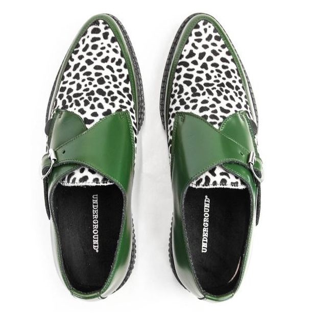 the image shows a pair of women's green leather ankle boots with a dalmatian print upper. the boots are a monk strap style, featuring a buckle closure. the shoes are pointedtoe and have a black and white dalmatianprint pattern on the top section of the shoe. the brand "underground" is visible on the inside of each shoe. the boots are displayed on a white background.