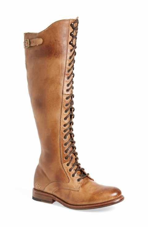 a pair of brown leather laceup boots are shown against a white background. the boots are tall, reaching the knee, and have a vintage, distressed look to the leather. the laces are tied up the front of the boots, and they have a slightly chunky heel.  the boots appear to be made of highquality leather.