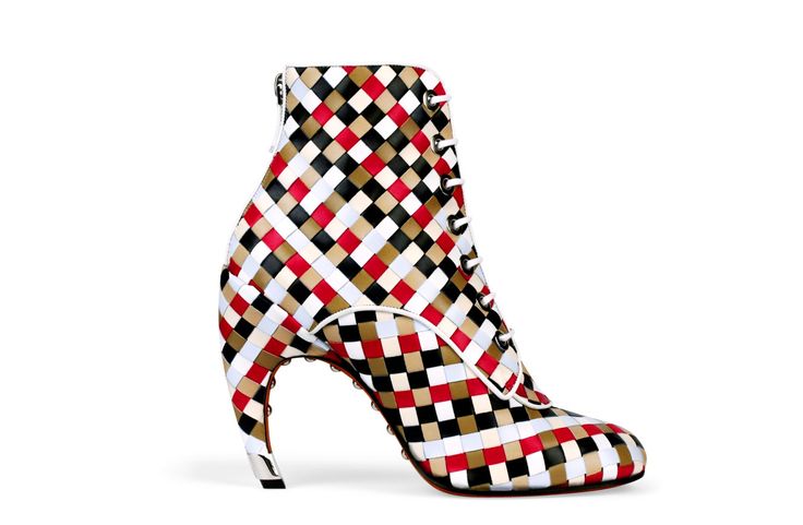 the image shows a single women's ankle boot on a white background. the boot is a high heel with a unique, curved heel. the boot's upper is made of woven leather in a checkered pattern of red, white, black, and beige. the boot has laceup closures. the style is modern, fashionable, and sophisticated.