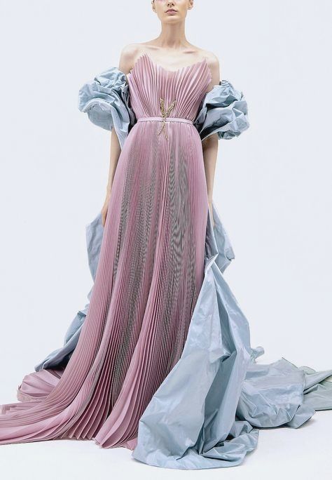a woman is wearing a long, pleated, dusty rose gown with puffed light blue sleeves and draped taffeta details. the dress has an offtheshoulder design and is accessorized with jewelry. the model is standing against a white background.