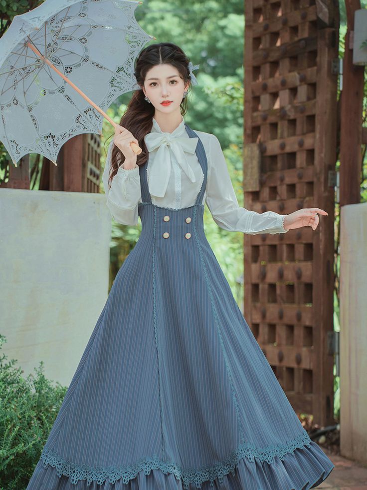 a woman in a vintageinspired blue dress and white blouse stands in a garden. she is holding a white lace parasol and looking at the camera. the dress has a long, flowing skirt with lace trim and a fitted bodice with decorative buttons. the garden features lush greenery and a wooden trellis. the lighting is soft and natural.  the overall aesthetic of the image evokes a romantic and whimsical feeling.