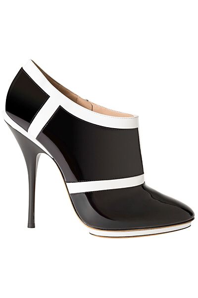a single, stylish black and white high heel shoe is presented on a white background. the shoe features a glossy black body accented with white trim, a pointed toe, and a stiletto heel.