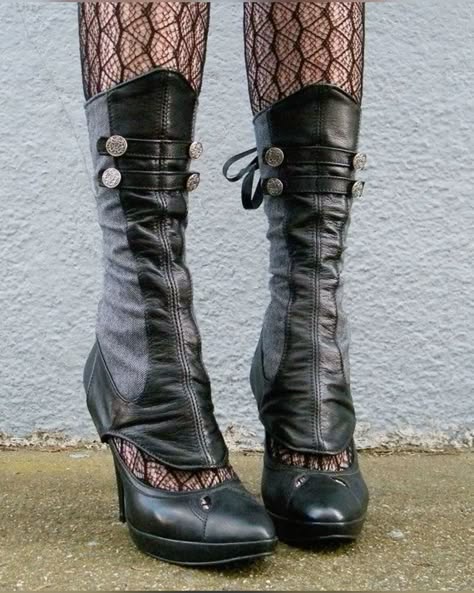 this image shows a pair of women's black leather high heeled boots, with grey fabric accents, worn over black lace stockings.