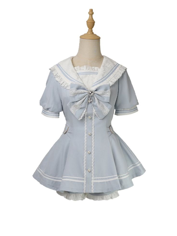 a light blue and white lolita fashion sailor dress is shown on a mannequin. the dress features a sailor collar, puffed short sleeves, and a flowing skirt. it is adorned with lace trim, a large bow, and pearl buttons.