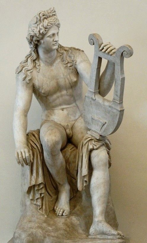 the image shows a marble sculpture of a nude male figure holding a lyre. the figure is seated, and the lyre is held in his left hand. the sculpture is in a classical style, reminiscent of greek or roman mythology.