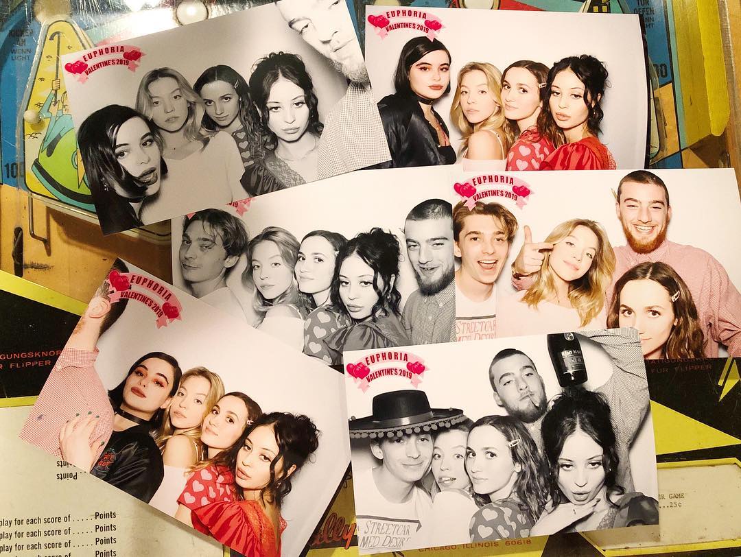 collage of numerous polaroidstyle photos from a euphoria valentine's day party in 2019.  the photos show various combinations of the cast and crew of the hbo show euphoria, posing in a photo booth. the photos are in black and white, and many show the individuals making various funny and playful expressions.  the photos are arranged somewhat haphazardly, giving a spontaneous feel to the image. the background includes a portion of an arcade game.