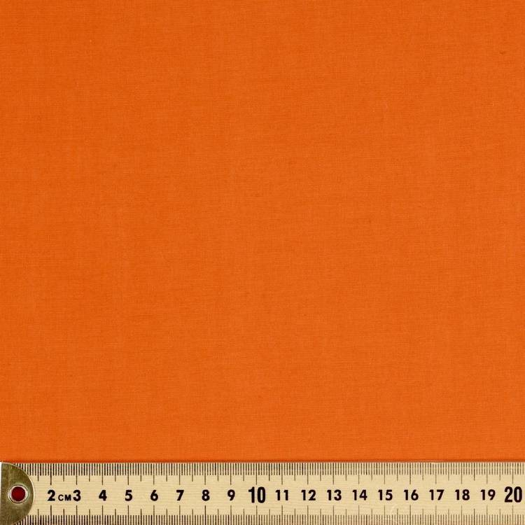 flat lay photograph of a vibrant orange fabric, likely used for sewing or crafts.  the top portion of the image showcases the fabric's texture and solid color, while the bottom reveals a measuring tape for scale, indicating the fabric's potential use in projects requiring specific dimensions.
