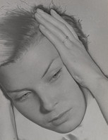 the image is a closeup black and white portrait of a young woman.  she appears to be in distress, with her hand resting on her forehead, suggesting tiredness, worry, or sadness. her expression is somber, and her eyes are downcast. the lighting and style of the photograph are reminiscent of vintage photography from the mid20th century (possibly 1940s or 1950s). the overall mood is one of melancholy and introspection.