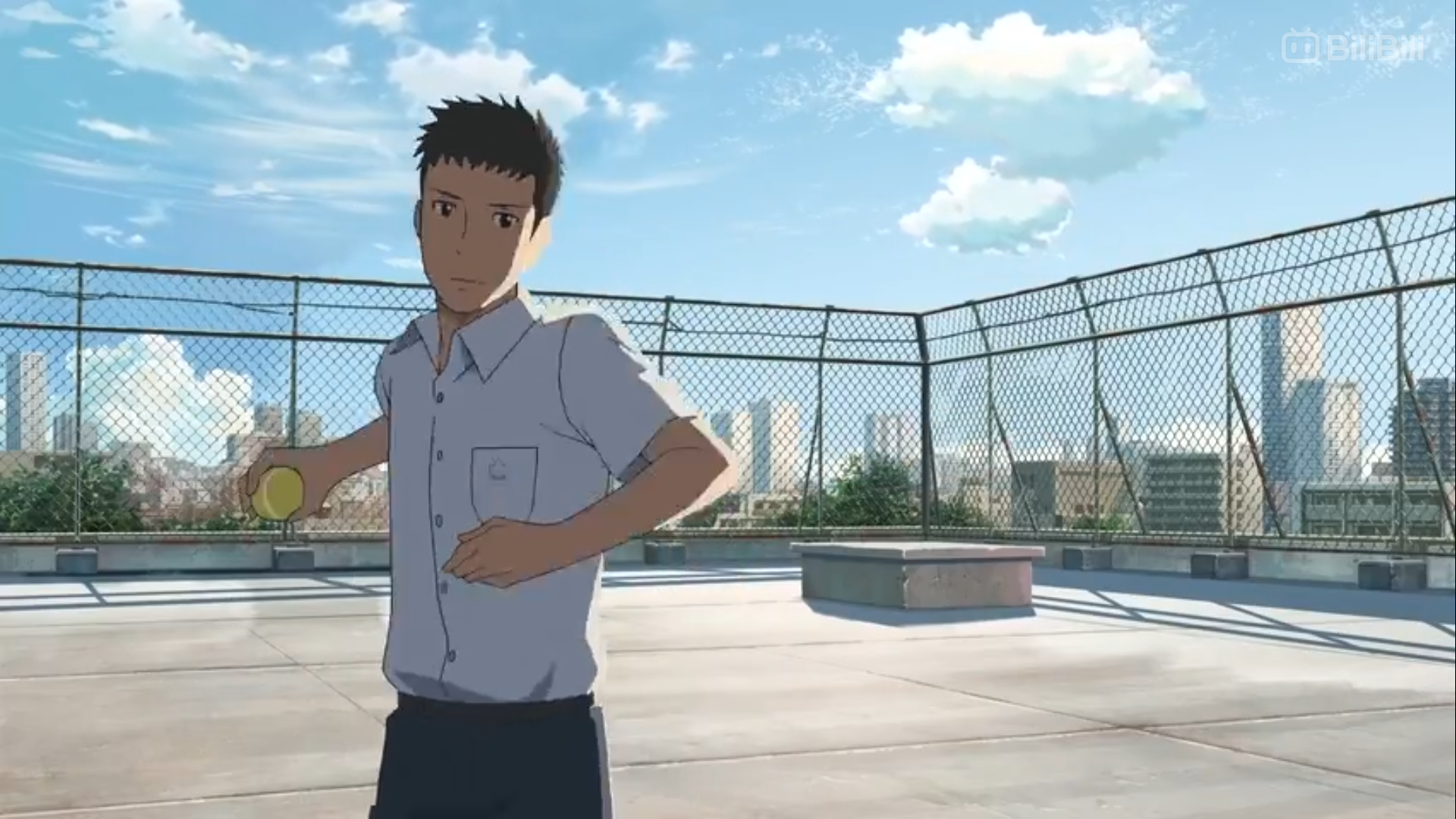 a young man in a school uniform stands on a rooftop in front of a cityscape. he is holding a tennis ball in his right hand. the sky is blue and there are some clouds.  the image is brightly lit and has a wide aspect ratio.
