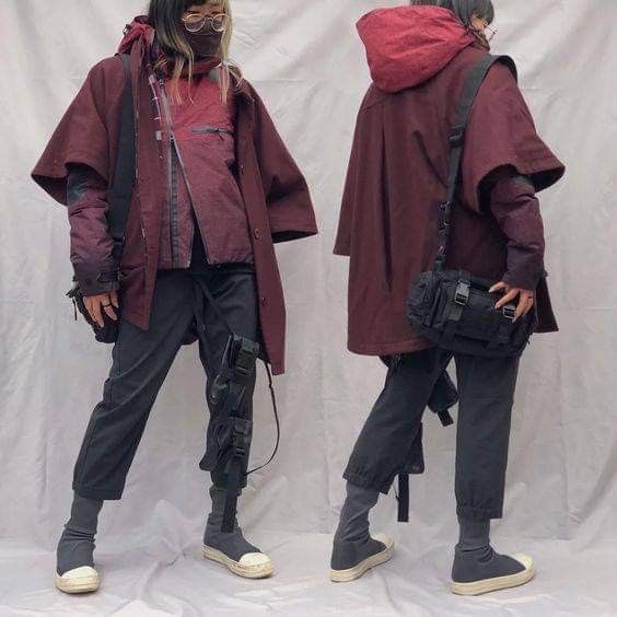 he image showcases two women wearing similar outfits, each posing individually against a lightgrey backdrop. the outfits feature dark maroon, almost burgundy, overcoats with a unique capelike design, black pants, and offwhite sneakers.  the coats are loosefitting and have a slightly oversized silhouette. each woman also carries a black shoulder bag.  their style could be described as dark streetwear or avantgarde fashion. the image's composition presents a sidebyside comparison of the outfits.
