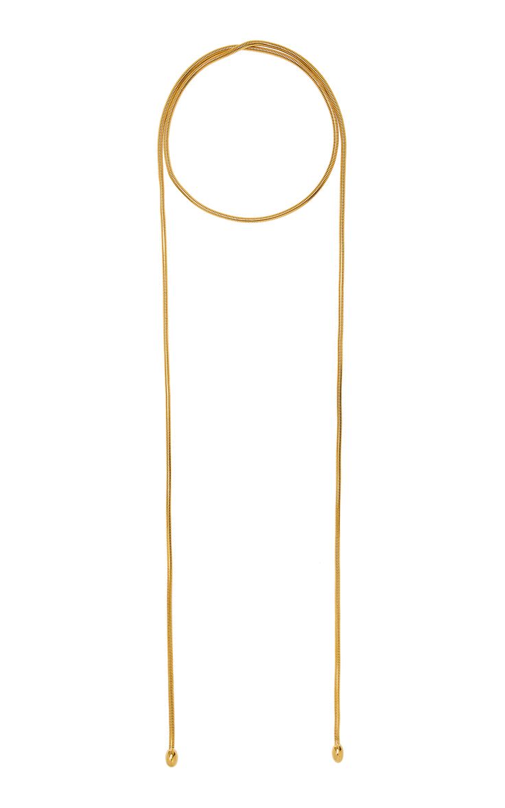 a gold necklace with a circle in the center and two long chains hanging down. the necklace is isolated on a white background.